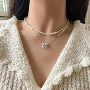 Close-up of double-layer S925 silver necklace with pearls and daisy flower pendant