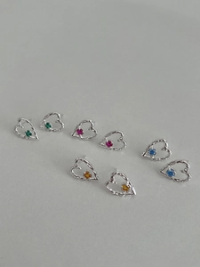 Macro view of S925 silver heart stud earrings with colorful zircon stones in various hues