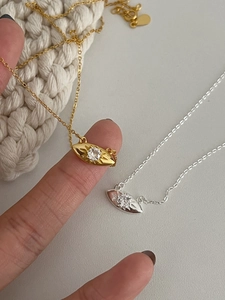 Vue macro de pendentifs œil en argent et or avec pierre de zircon et rayons gravés
