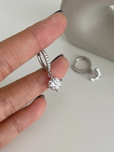 Vue macro de boucles d'oreilles en argent avec moissanite à six griffes et pavé