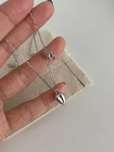 Macro view of polished S925 sterling silver heart pendant on a thin O-chain link