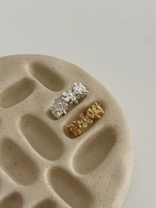 Detailed close-up of S925 silver flower rings with sparkling zircon pave in gold and silver