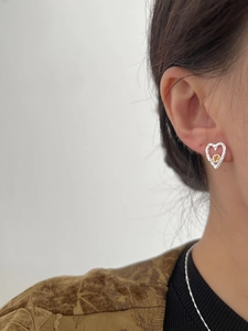 Detailed close-up of a heart-shaped S925 silver earring with a bright orange zircon gem