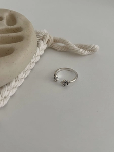 Gros plan d'une bague large rétro en argent S925 avec détails papillon et croix