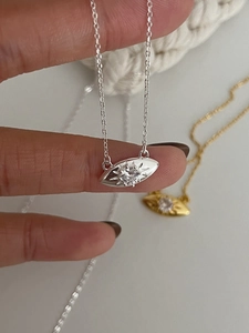 Gros plan de pendentifs œil en argent S925 et or avec un cristal de zircon brillant
