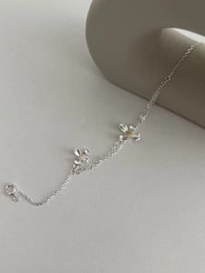 Détail d'un bracelet double en argent avec breloques de gardénia mat et fermoir à ressort