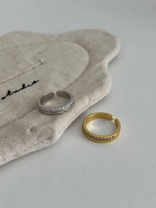 Detail of adjustable S925 sterling silver rings with single row zircon stones in gold and silver