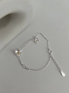 Détail du bracelet fleur de gardénia en argent avec centre jaune et double chaînette