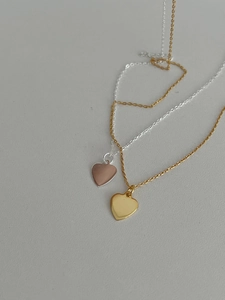 Detailed view of polished heart-shaped pendants in rose gold and yellow gold plating