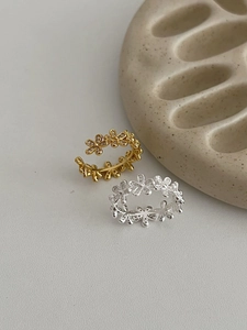 Detail of adjustable gold and silver flower rings with cubic zirconia pavé setting