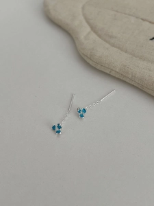 Macro detail of S925 silver iris earrings with blue enamel petals and zircon center