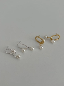 Detail of gold and silver twisted oval hoop earrings with dual white pearls hanging