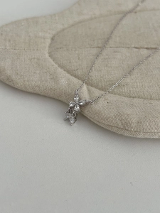 Macro shot of silver butterfly pendant with marquise-cut stones on linen texture
