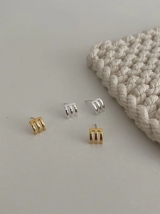 Macro detail of S925 sterling silver three-claw curved stud earrings in gold and silver