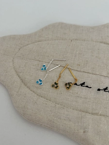 Detail of clover chain earrings with blue and green enamel and small center diamonds