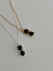 Détail de colliers chat argent et or avec pendentifs agate noire et accents en pierre