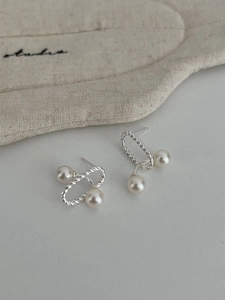 Macro detail of 925 silver twist rope hoop earrings with elegant white natural pearls