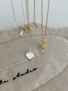 Close-up of minimalist S925 silver heart necklaces in gold and silver finishes