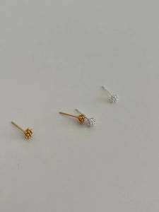 Detail of pine cone shaped silver and gold earrings with minimalist floral bead textures