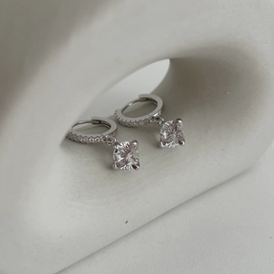 Élégantes boucles d'oreilles en argent S925 avec moissanite à six griffes sur support blanc