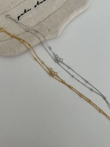 Detail of gold and silver S925 bow bracelets with sparkling zircons on a soft gift bag