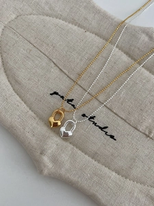 Dettaglio di pendenti a cuore in argento S925 con anelli intrecciati in oro e argento
