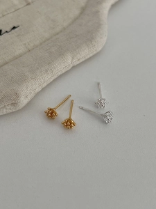 Macro detail of gold and silver pine cone stud earrings in S925 sterling silver