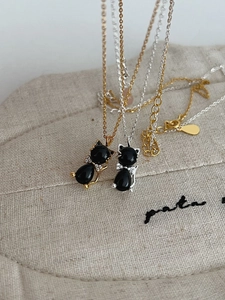 Gros plan détaillé du collier pendentif chat en agate noire avec nœud papillon en diamant
