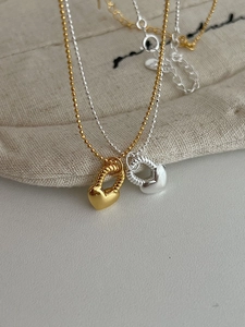 Dettaglio di collane a cuore in argento S925 in finitura oro e argento con catenine