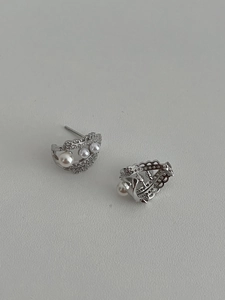 Macro detail of S925 silver lace earrings with white pearls and sparkling cubic zirconia
