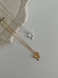 Detailed shot of S925 silver bow pendant necklaces in gold and silver mirror finishes