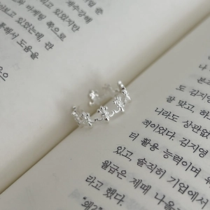 Vintage S925 silver iris flower crown ring displayed on an open book with soft lighting