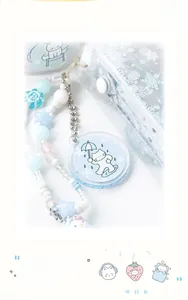 Macro detail of a beaded phone strap with a cute cat acrylic charm and blue star beads