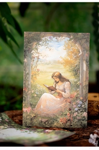 Nahaufnahme einer Vintage-Papierkarte mit Illustration einer lesenden Frau im Wald