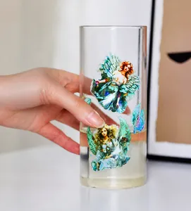 Iridescent angel stickers with shell luster applied to a clear glass cup for DIY decor
