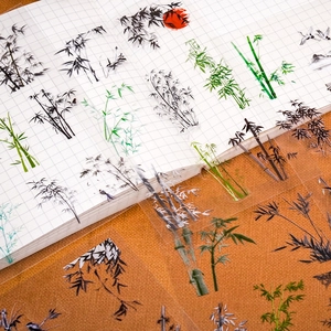 Ink-style PET stickers with bamboo and crane motifs on a grid notebook for journaling