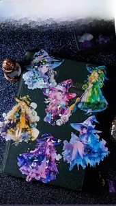 Detail of holographic anime witch stickers with glittering shell light effect on black paper