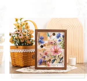 Dettaglio di adesivi PET floreali in cornice di legno con elementi collage in stile vintage