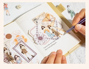 Detail of vintage character PET tape stickers being applied to a journal with tweezers