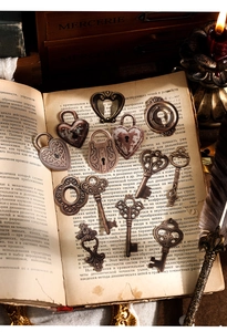 Vista macro di ciondoli a cuore e chiavi vintage in bronzo su pagine di un libro antico