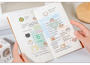 Close-up of cute animal stickers and weekly plan grid layout in a creative journal
