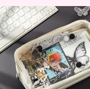 Detail of a beige canvas pouch with anime cards and stationery in a lifestyle setup