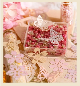 Gros plan détaillé de papillons en papier ajouré et fleurs séchées pour scrapbooking
