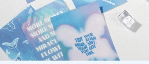 Detailed view of dreamy holographic butterfly stickers with motivational quotes on blue paper