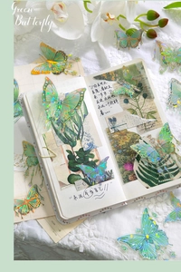 Close-up of green butterfly stickers with metallic luster on white lace background