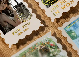 Macro shot of gold foil stamp stickers featuring anime girl illustrations for journals