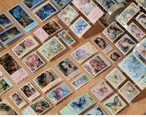 Detail of vintage stamp-shaped stickers with gold foil accents on a wooden desk