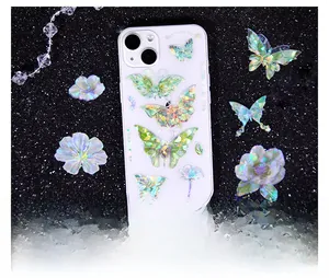 Detailed holographic butterfly floral stickers on a clear iPhone case with a glitter backdrop