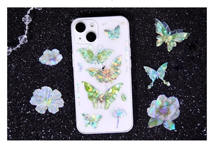 Macro view of iridescent butterfly and floral pattern on white iPhone case with laser finish