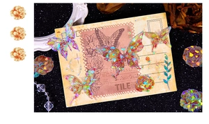 Detail of holographic butterfly floral stickers on a vintage postcard for journaling